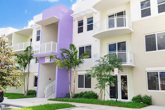 A white and purple building with balconies and windows.