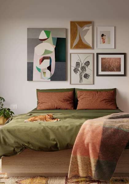 a bedroom with a bed and paintings on the wall