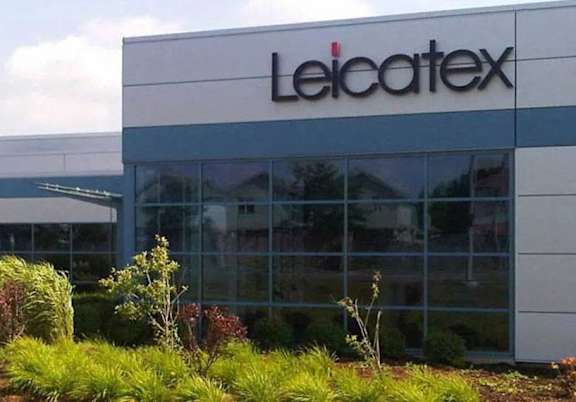 The Leicatex building has a white and grey exterior with a large glass window.