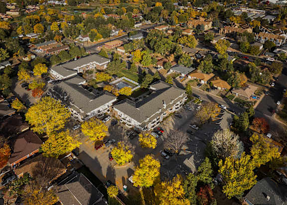 A beautiful aerial view of a park with a pond and a winding road.