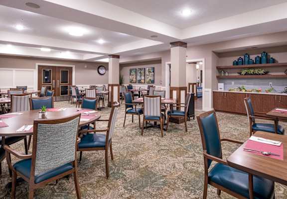 a large dining room with tables and chairs and a bar