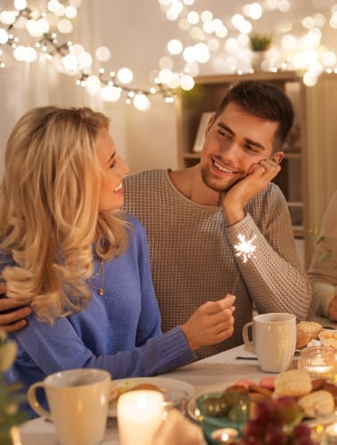 a group of people sitting around a dinner table with lit candles