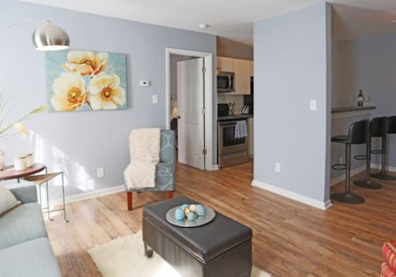 A living room with a grey couch, a coffee table with three eggs on it, and a painting of flowers on the wall.at Creekside Canopy, Charlotte, NC 28212
