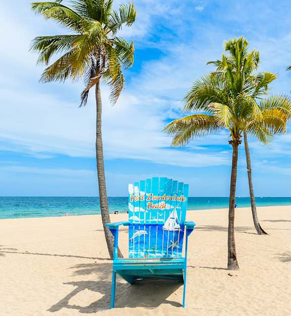 Fort Lauderdale Beach blue chair amongst the sand and trees - neighborhood photos