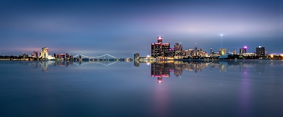 A city skyline is reflected in the water at night.