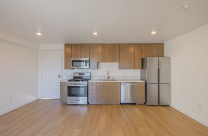 A modern kitchen with stainless steel appliances and wooden cabinets.
