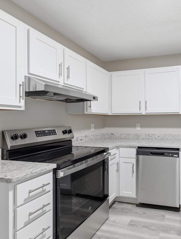 A kitchen with white cabinets and appliances.