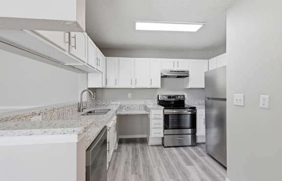 A modern kitchen with stainless steel appliances and white cabinets.