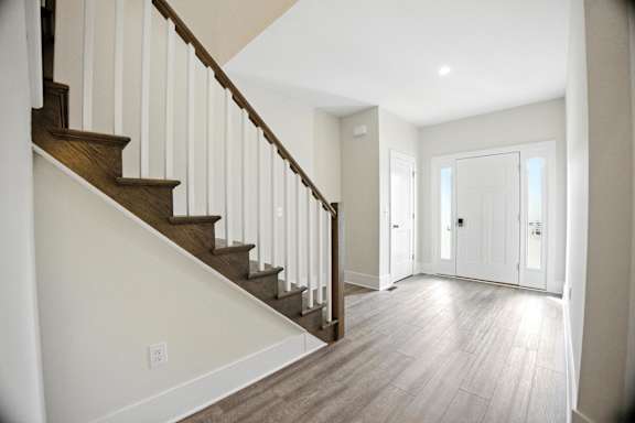 A staircase with a white wall and wooden steps.