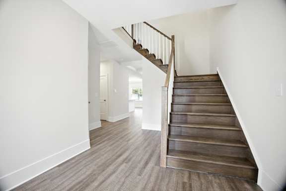 A wooden staircase leads up to a landing with a doorway.