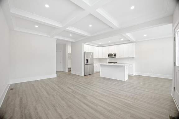 A spacious kitchen with a refrigerator, sink, and cabinets.