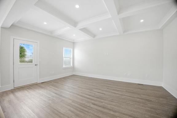 A room with a white door and a window with a view of a tree and a building outside.