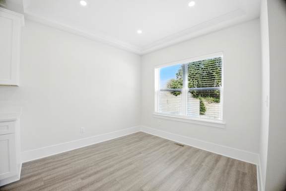 A room with a window showing a view of a green tree.