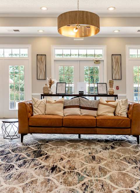 A large, modern living room with a sofa, chairs, and a rug.