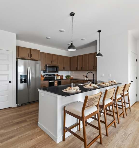 A kitchen with wooden chairs and a black countertop.