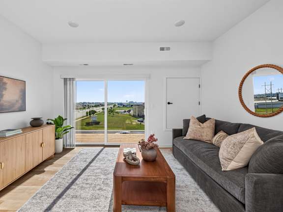 A living room with a grey couch and a wooden coffee table.