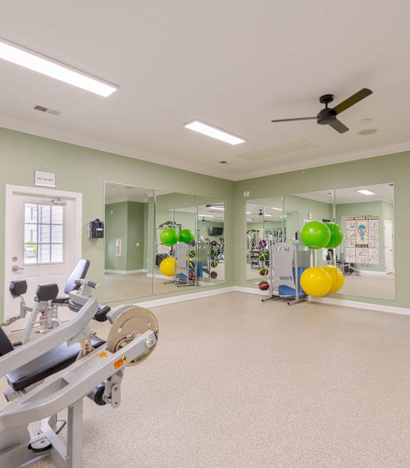 A spacious gym with a row of treadmills and exercise equipment.