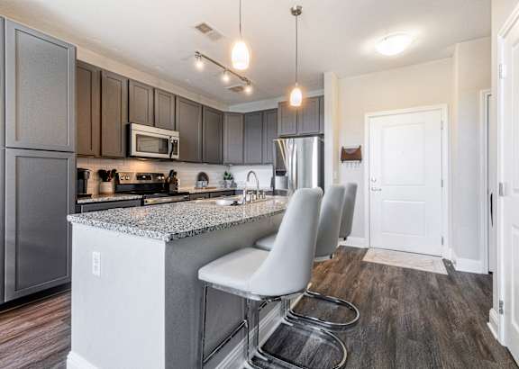 a living room filled with furniture and a flat screen tv at Streets of Greenbrier in Chesapeake, VA 23320