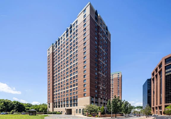 an apartment building on a city street with a blue car  at 15 Bank Apartments, White Plains, NY
