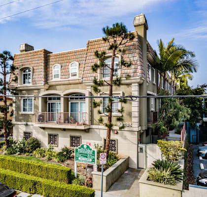 a house with a shingled roof and a street sign in front of it