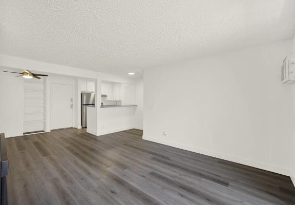 A room with a wooden floor and a ceiling fan.