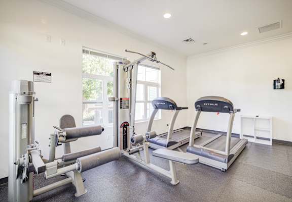 A gym with a treadmill, weights and a bench press. at Valencia at Gale Ranch, San Ramon, CA, 94582