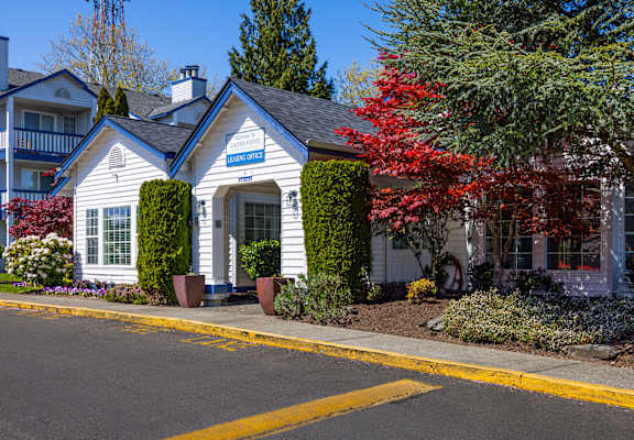 A small white house with a blue sign on the front door.