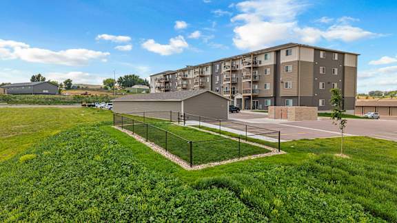 A large grassy area in front of apartment buildings.