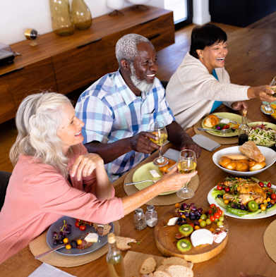 A group of people toasting with wine glasses at a dinner table.