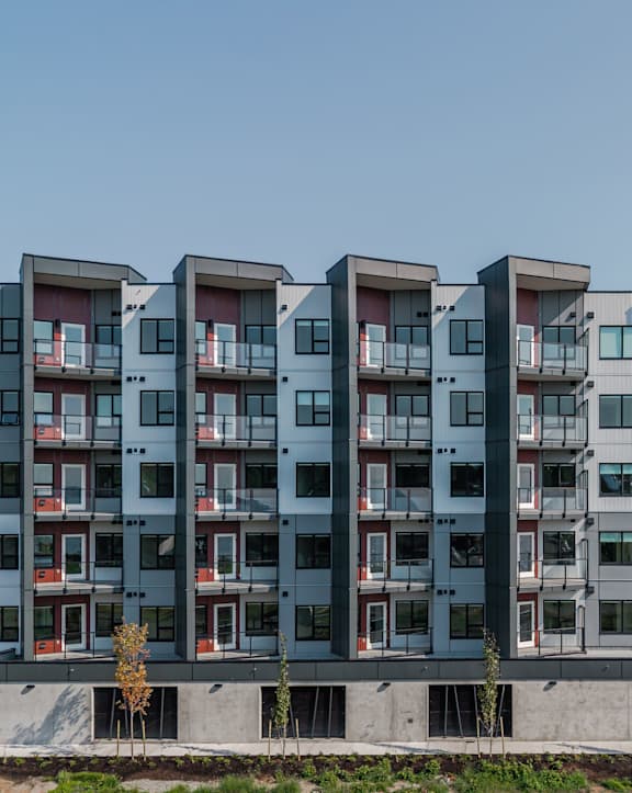 A modern apartment building with balconies overlooking the ocean.