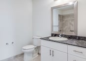 Thumbnail 7 of 7 - A white toilet sits next to a sink in a bathroom.