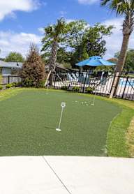 A backyard with a green lawn and a pool table.