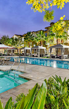 a swimming pool with lounge chairs and umbrellas at Capriana at Chino Hills, Chino Hills, CA, 91709