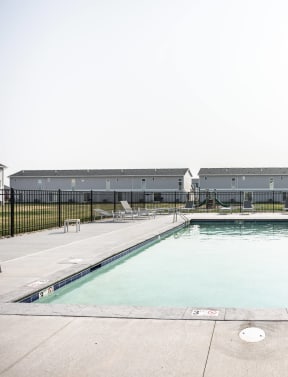 a swimming pool with a house in the background