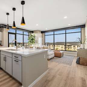 A modern kitchen with a large island and pendant lights.