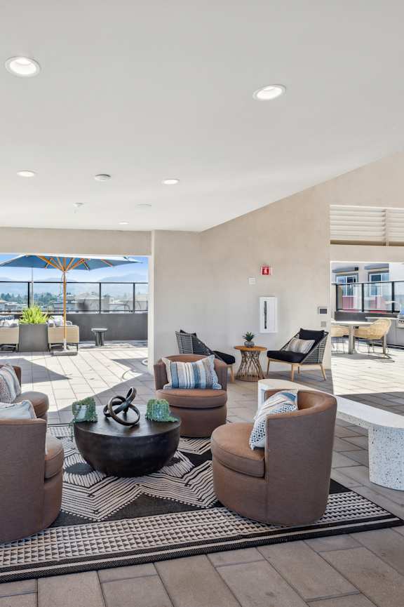 A modern living room with a large window overlooking a balcony.