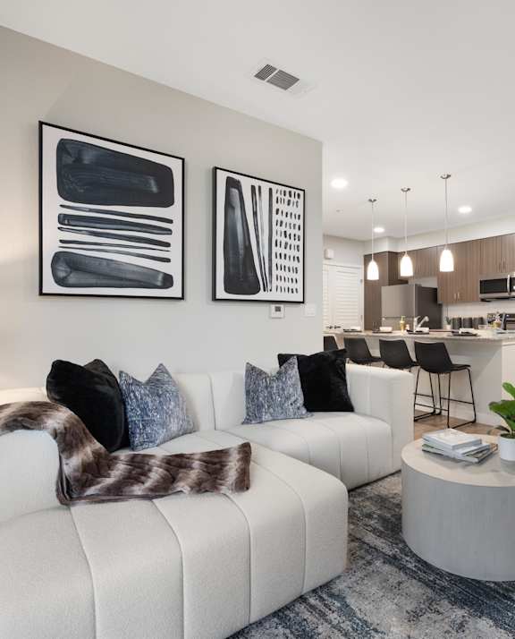 A modern living room with a white couch and a coffee table.