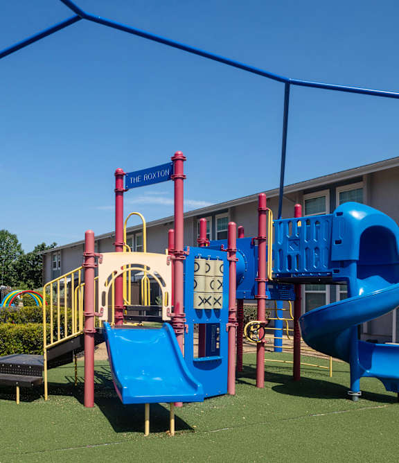 A modern apartment complex with a well-maintained lawn in front.