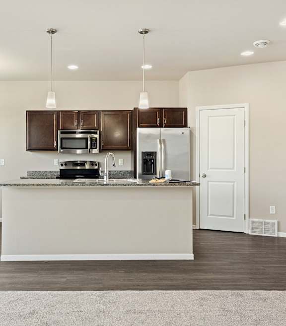 A kitchen with a white counter and brown cabinets.