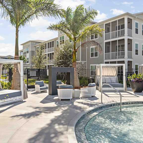 our apartments have a large swimming pool with an umbrella at Verity Luxury Apartments, Vero Beach, FL 32960