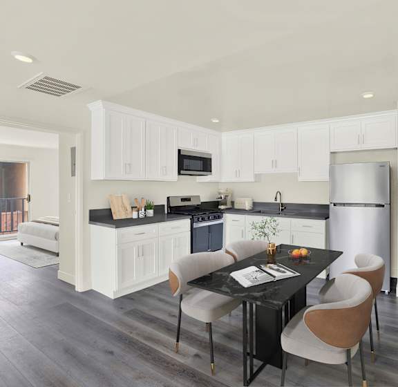 A modern kitchen with a dining table and chairs.