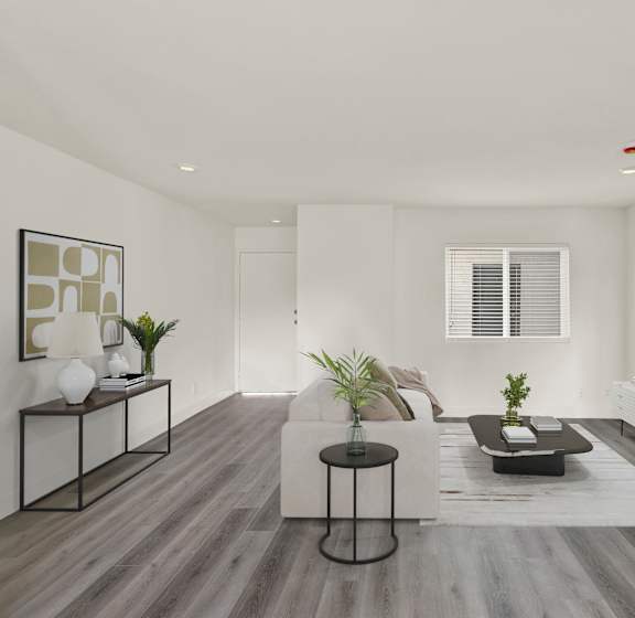 A modern living room with a white couch, a black coffee table, and a TV on the wall.