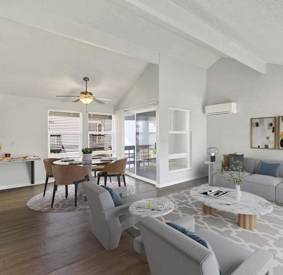 A modern living room with a grey sofa, a coffee table, and a dining table set up.