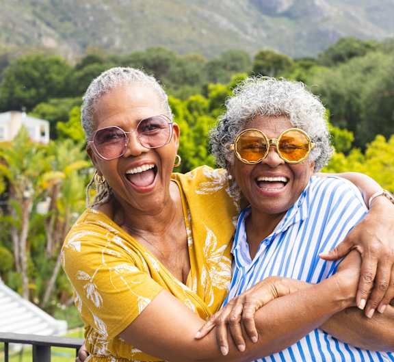 Two women hugging each other in a garden.