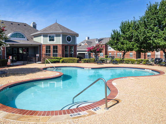 A swimming pool with a brick border and a slide.