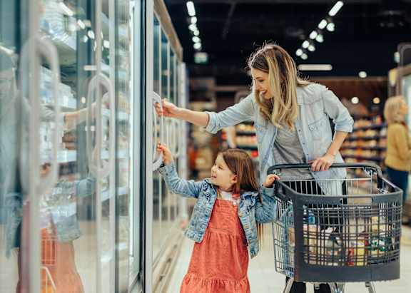 A woman and a young girl are shopping in a store.