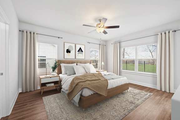 A bedroom with a large bed and a ceiling fan.