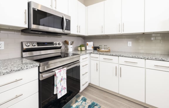 a modern kitchen with white cabinets and stainless steel appliances