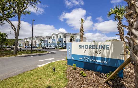 A sign for Shoreline Villas is in front of a row of houses.