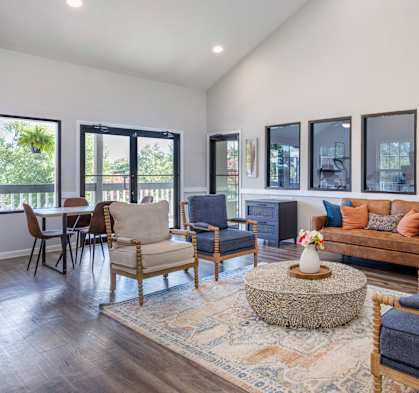 A living room with a blue chair and a brown couch.